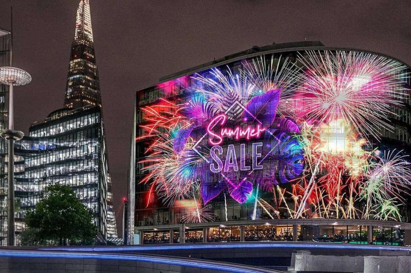 Transparent advertising LED screen covering a glass building facade