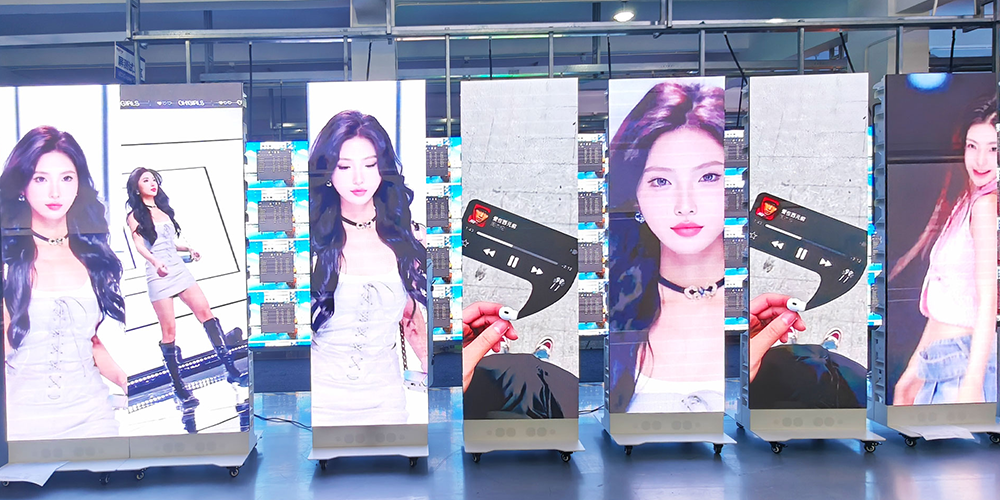 LED poster display-2 - LED Screen Board - LED Screen Board Row of tall display panels showing a female model in white outfits in a bright showroom setting.