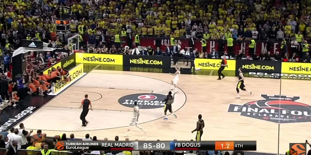 体7 Basketball game in a packed arena: Real Madrid leads FB Dogus 85–80 in the EuroLeague with 1.2 left in the 4th, yellow-clad fans cheering.