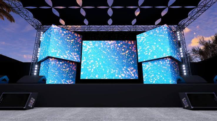 展厅es - LED Screen Board - LED Screen Board Outdoor concert stage with three glowing blue screens and overhead truss lighting at dusk/dawn twilight