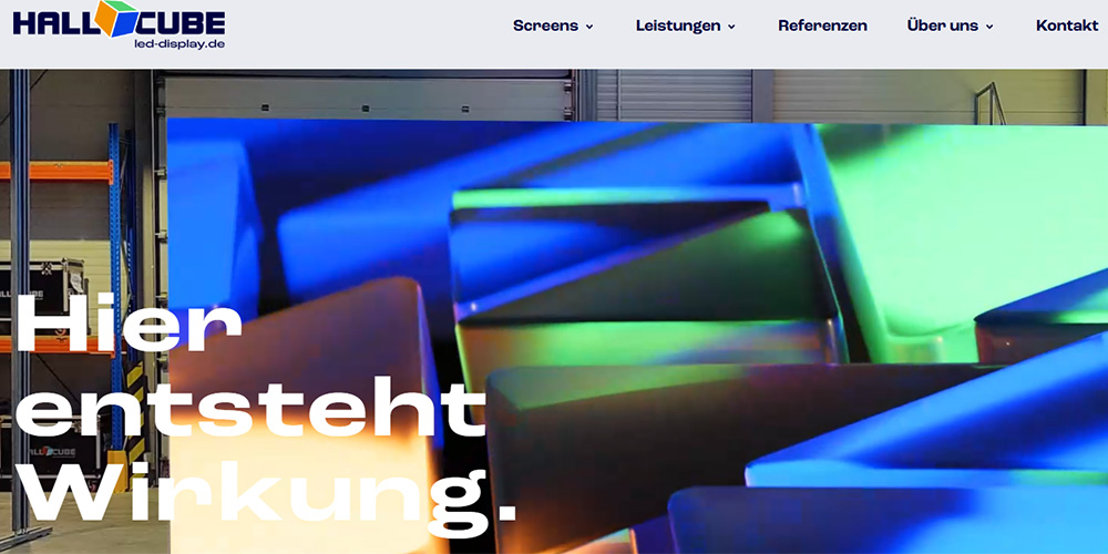 Hero image of colorful display panels in a warehouse, with HallCube logo and the German headline 'Hier entsteht Wirkung'.