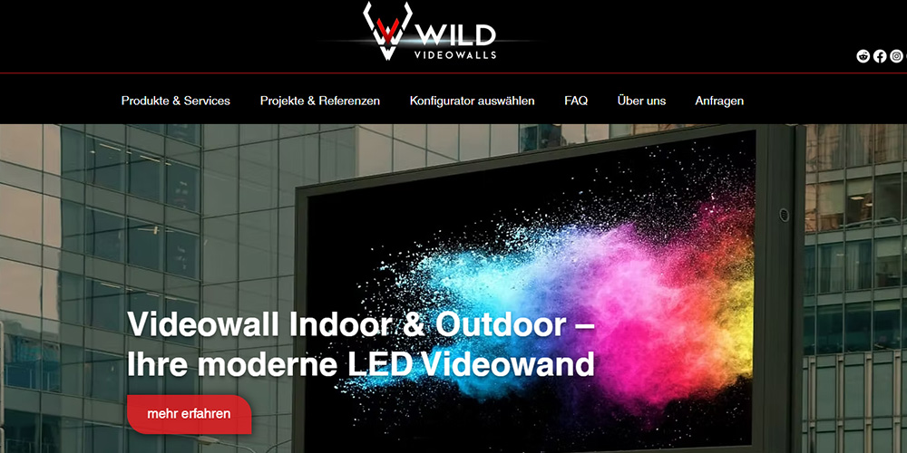 Large outdoor LED videowall mounted on a glass-front building, displaying a colorful splash; overlay reads 'Videowall Indoor & Outdoor – Ihre moderne LED Videowand' with a red 'mehr erfahren' button.