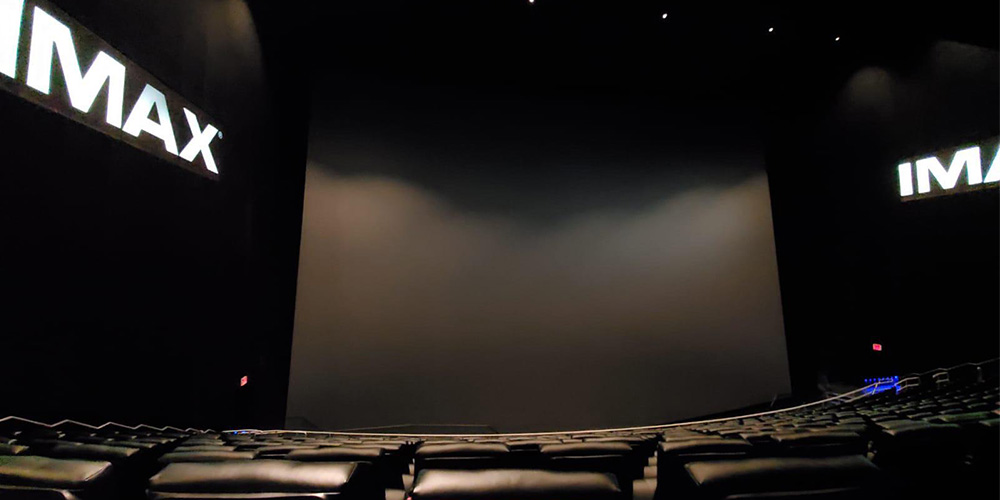 03-AMC-Lincoln-Square-13 - LED Screen Board - LED Screen Board Empty IMAX theater with a huge curved screen and rows of dark seats.