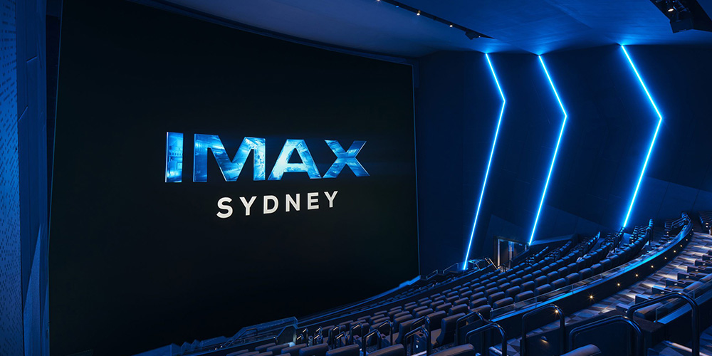 09-IMAX-Sydney - LED Screen Board - LED Screen Board Empty IMAX Sydney theater with a massive screen and blue neon wall lighting, rows of dark seats curving toward the screen