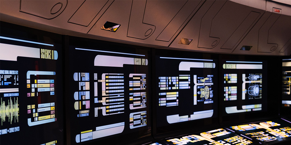 Black LED Display4 - LED Screen Board - LED Screen Board Futuristic ship console with multiple glowing screens displaying colorful data readouts and panels.