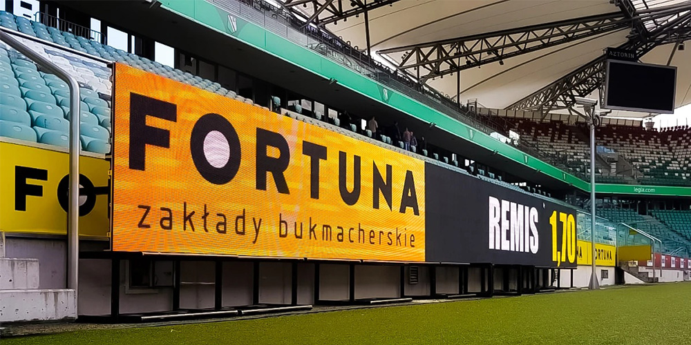 Stadium perimeter LED display beside a football pitch