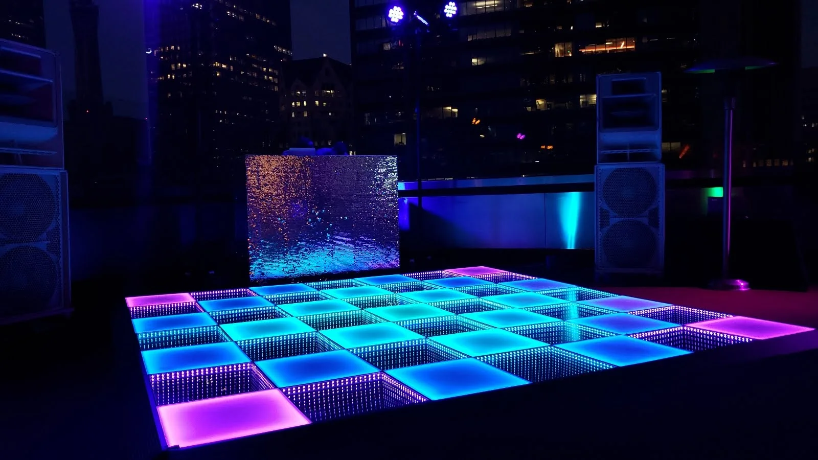 Decorative LED dance floor with blue and purple illuminated square panels at an event