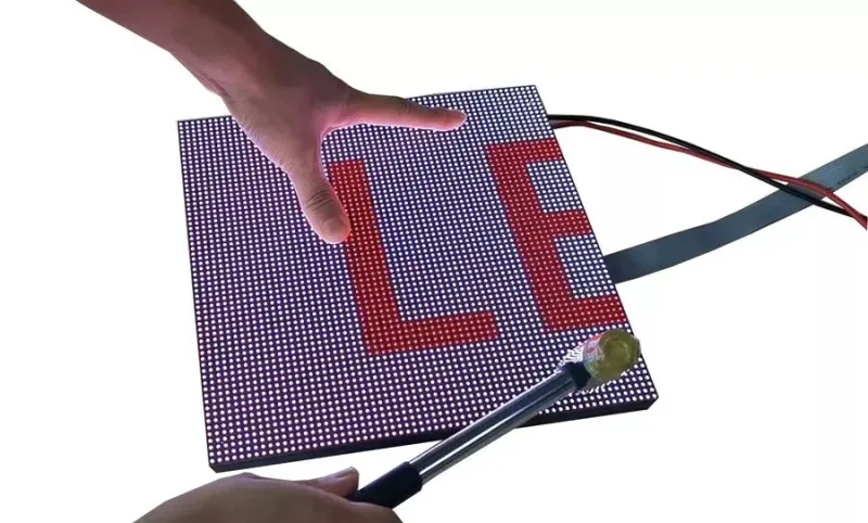 GOB LED module contact demonstration with a hammer beside an illuminated panel